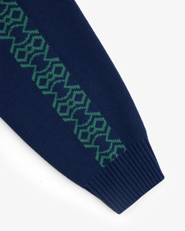 Close-up of the Knit Sport Pullover’s navy sleeve with a green geometric pattern along its length.