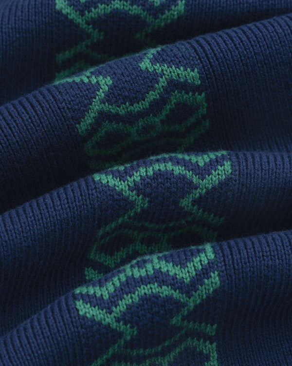Close-up of Knit Sport Pullover’s dark blue ribbed fabric with green geometric patterns woven in.