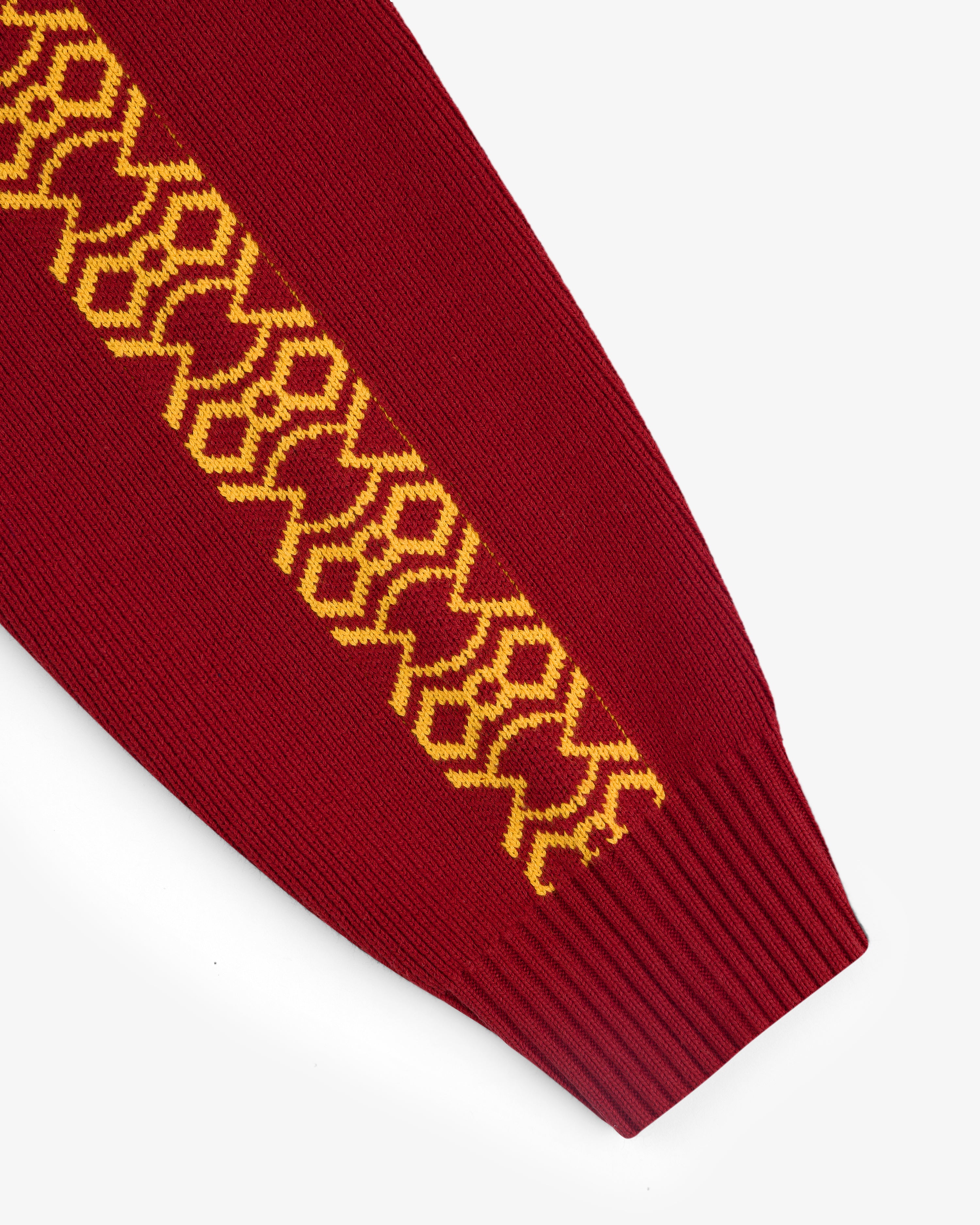 Knit Sport Pullover: Red sleeve with yellow geometric pattern along the length, finished with a ribbed cuff.