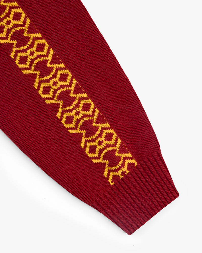Knit Sport Pullover: Red sleeve with yellow geometric pattern along the length, finished with a ribbed cuff.