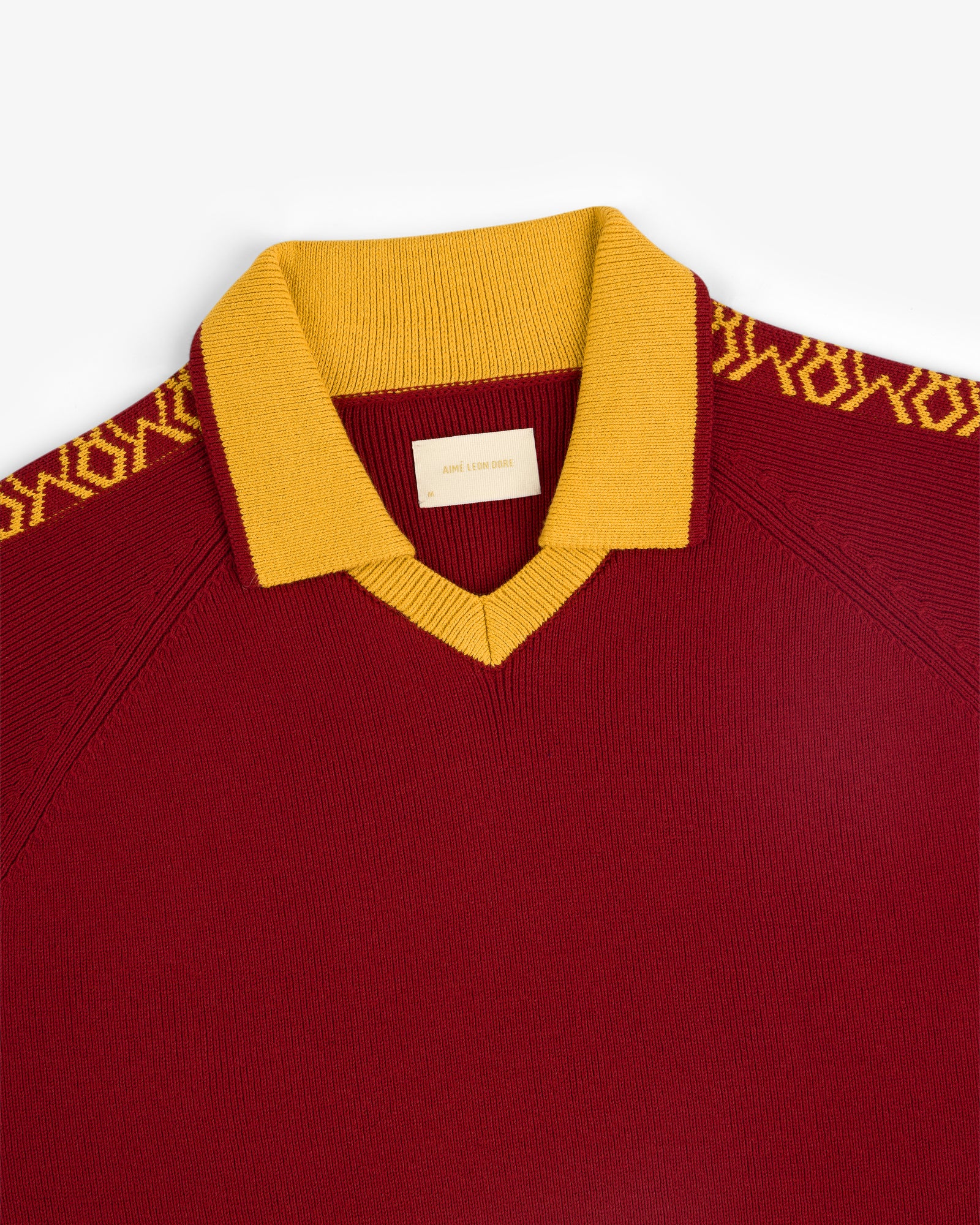 Knit Sport Pullover in maroon with yellow collar and geometric shoulder patterns.