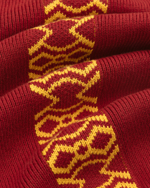 Close-up of the Knit Sport Pullover, featuring red knit fabric with a yellow geometric pattern.