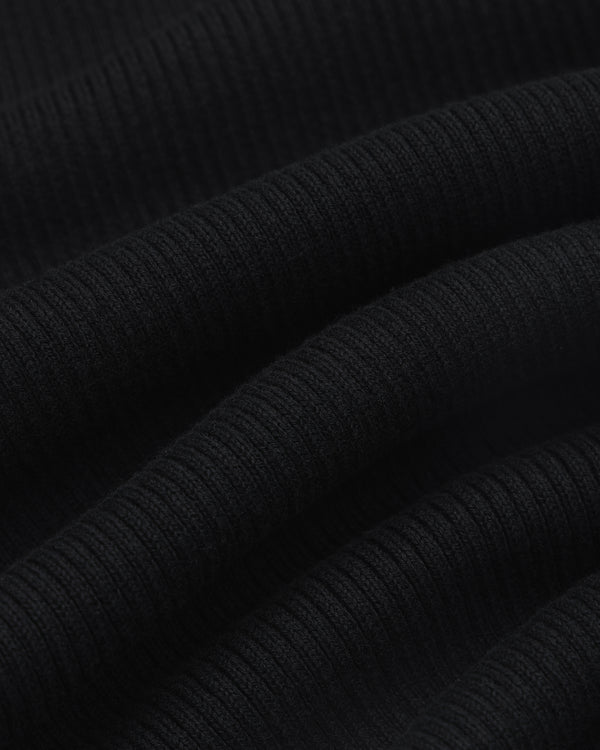 Close-up of black ribbed Sport Knit Henley fabric with soft, wavy folds and a textured surface.