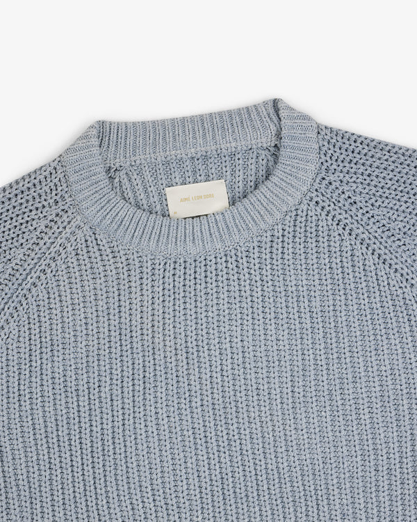Knit Denim Crewneck Sweater in light blue, laid flat on a white background with visible collar tag.
