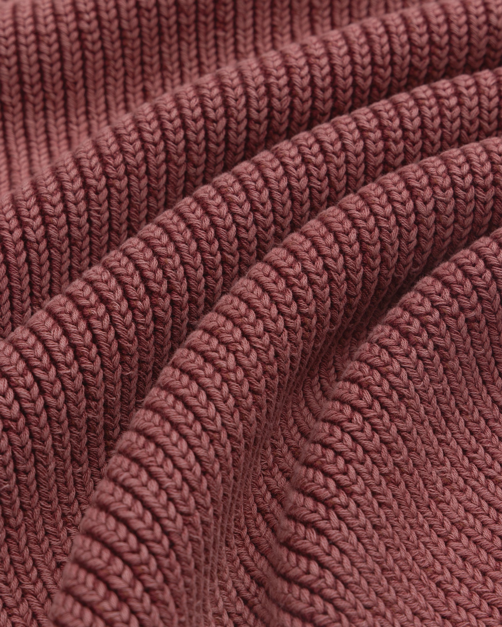 Close-up of the textured ribbed fabric and wavy folds on the maroon Stone Washed Knit Polo.
