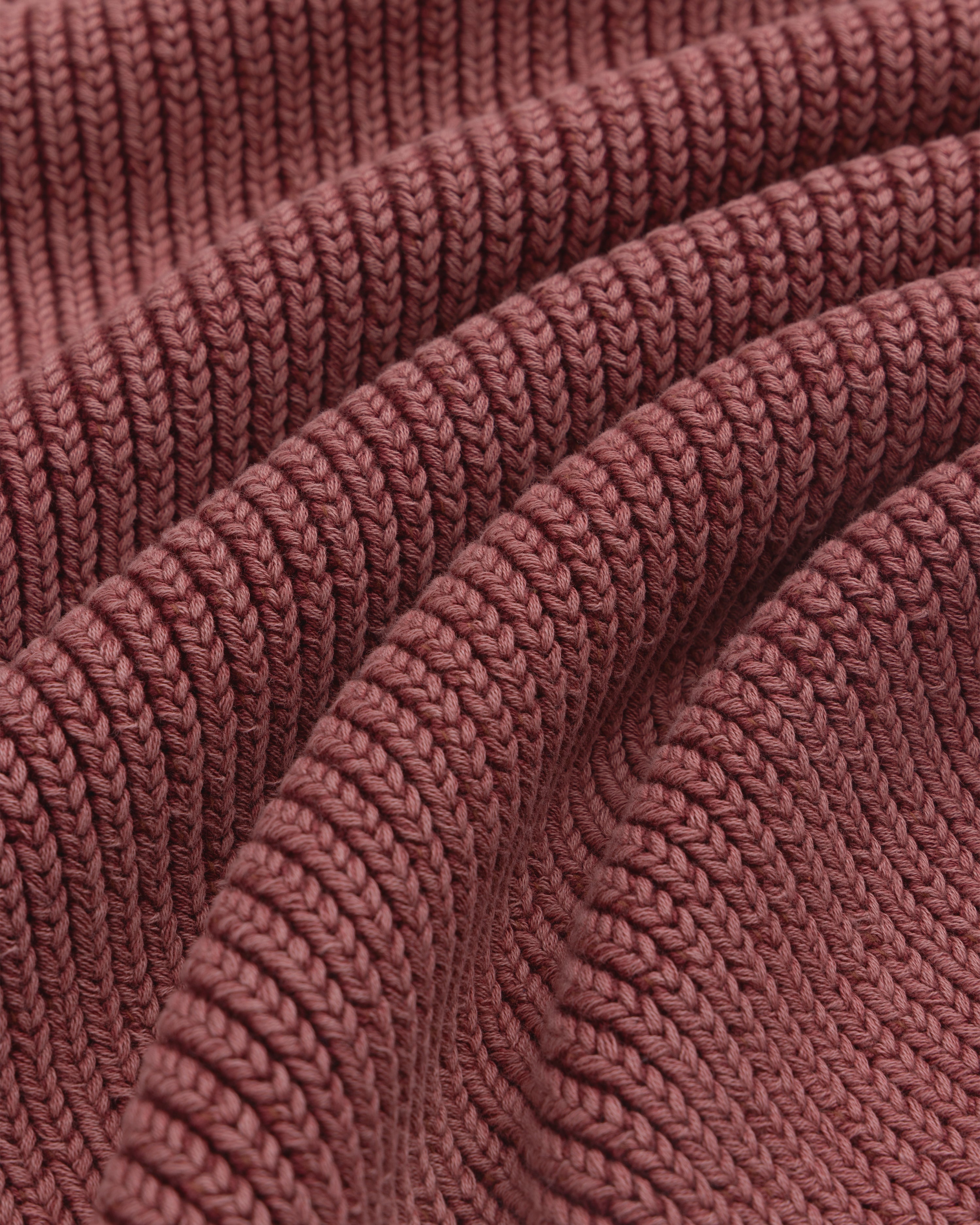 Close-up of the textured ribbed fabric and wavy folds on the maroon Stone Washed Knit Polo.