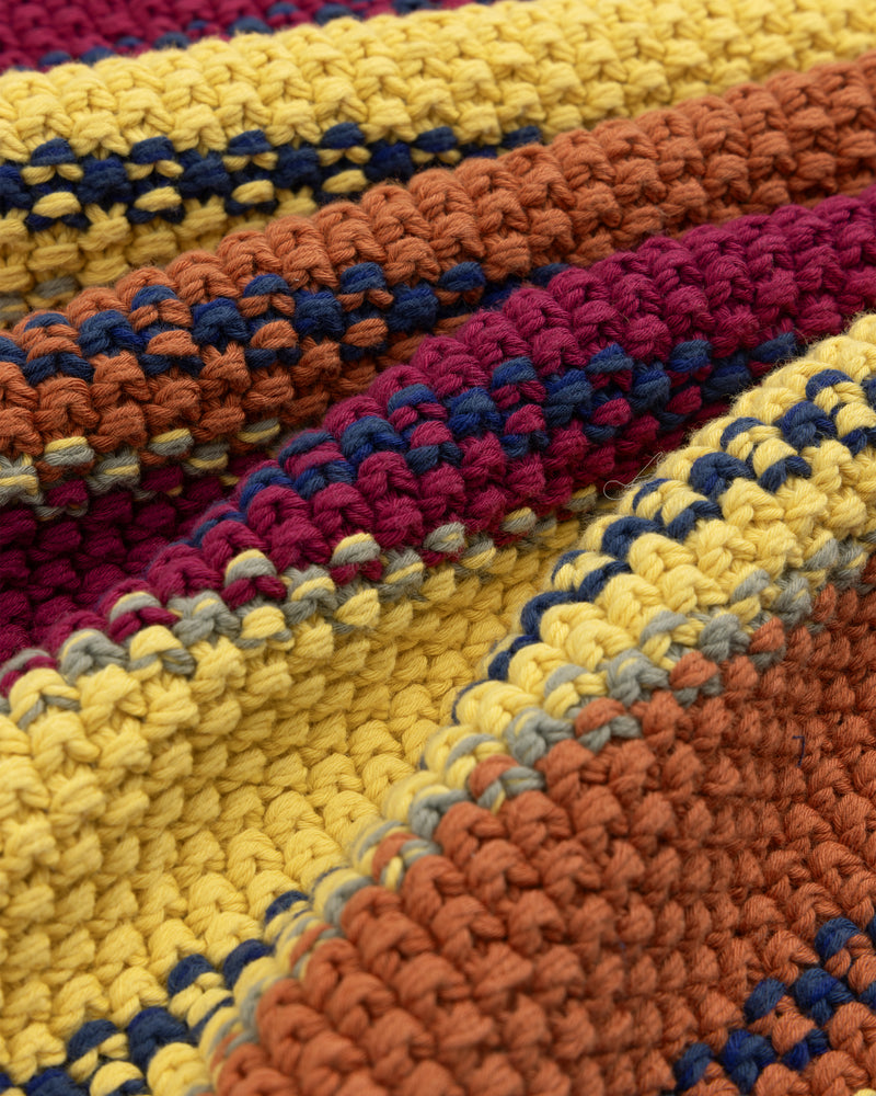 Close-up of a colorful Striped Rollneck Sweater with yellow, orange, burgundy, and blue yarn stripes.