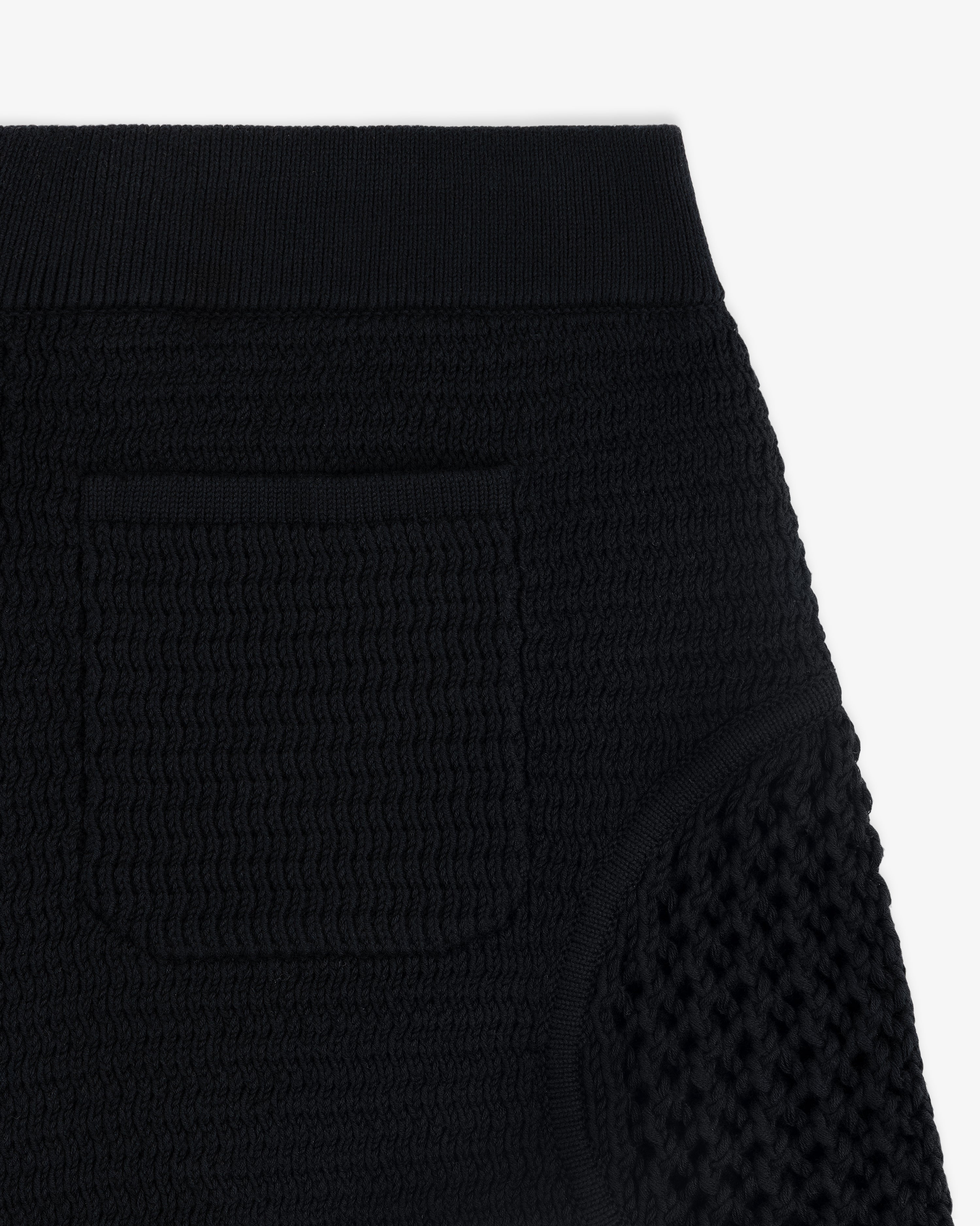 Close-up of the Knit Court Short in black, featuring textured knit, ribbed waistband, and small front pocket.