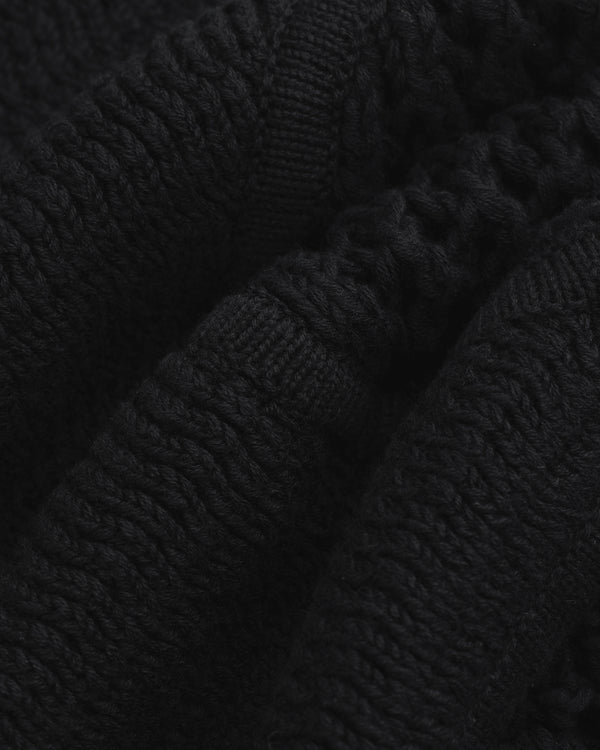 Close-up of Knit Court Short's black knitted fabric with textured patterns and soft, wavy folds.