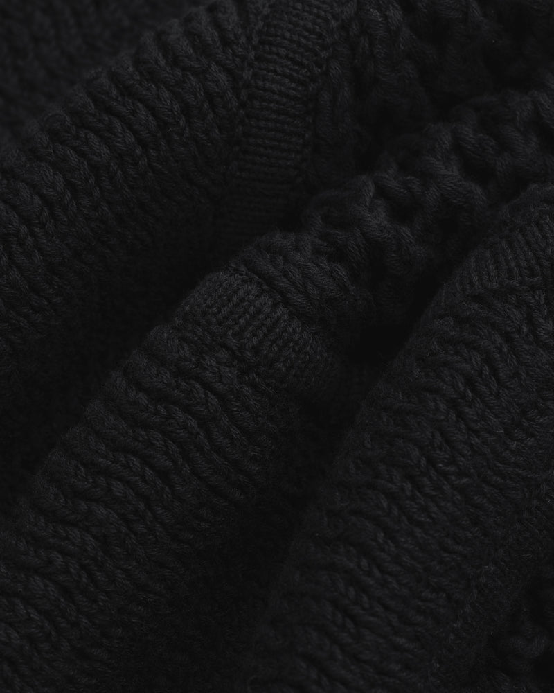 Close-up of Knit Court Short's black knitted fabric with textured patterns and soft, wavy folds.