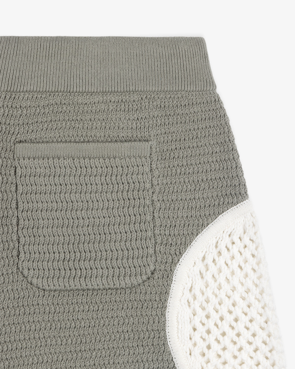 Close-up of the Knit Court Short, featuring textured gray knit fabric, a pocket, and a white knit side panel.
