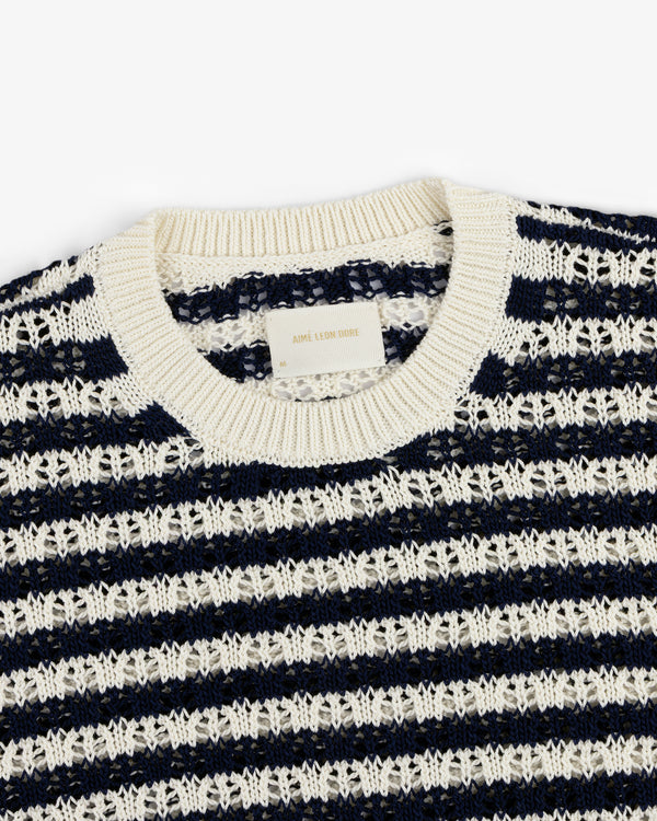 A close-up of the Skáfos Sweater, featuring navy blue and white stripes and a ribbed crew neckline.