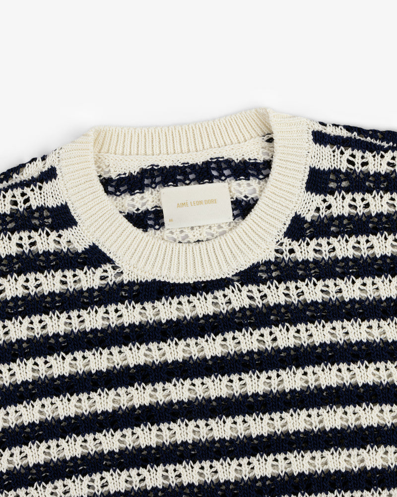 A close-up of the Skáfos Sweater, featuring navy blue and white stripes and a ribbed crew neckline.