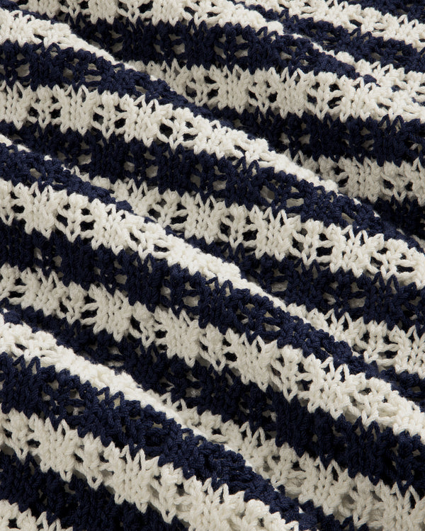 Close-up of the Skáfos Sweater’s knitted fabric with navy blue and white textured horizontal stripes.