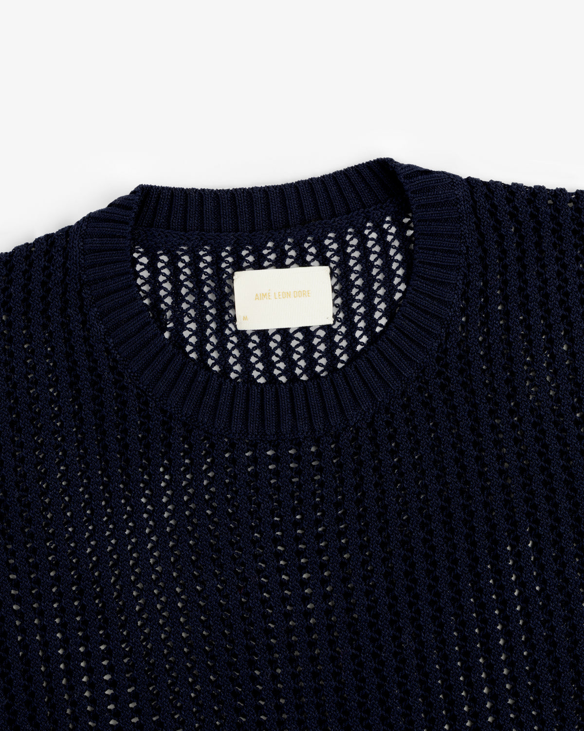 Navy blue Cotton Eyelet Crewneck Sweater with a ribbed collar and an Aimé Leon Dore label inside the neckline.