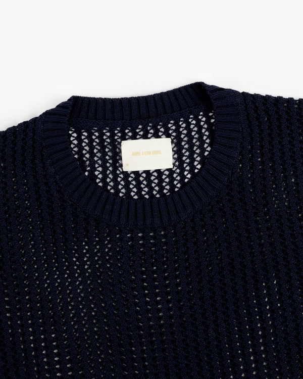 Navy blue Cotton Eyelet Crewneck Sweater with a ribbed collar and an Aimé Leon Dore label inside the neckline.