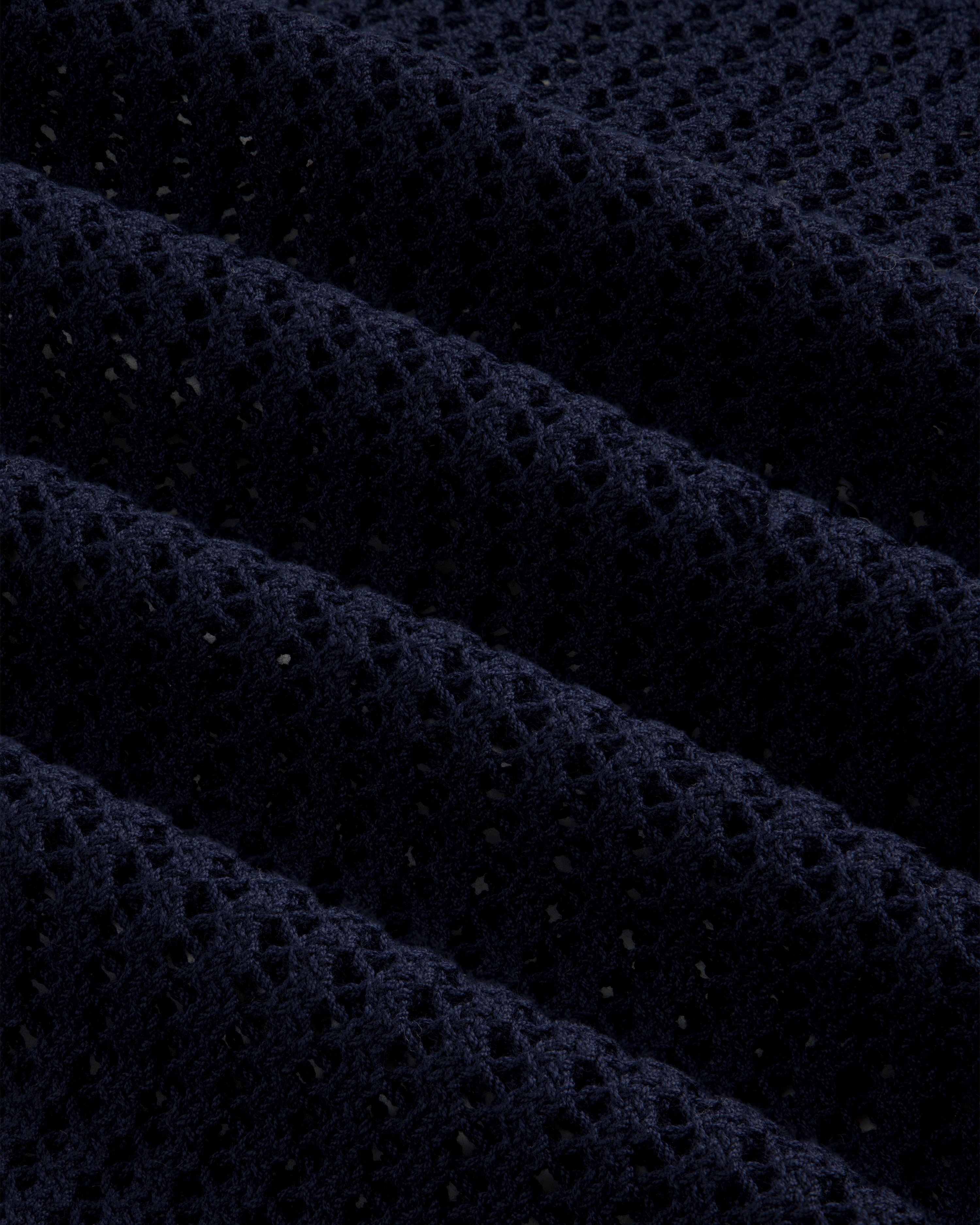 Close-up of the Cotton Eyelet Crewneck Sweater in dark blue, featuring textured waffle-knit and small perforations.