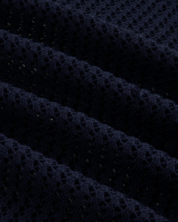 Close-up of the Cotton Eyelet Crewneck Sweater in dark blue, featuring textured waffle-knit and small perforations.