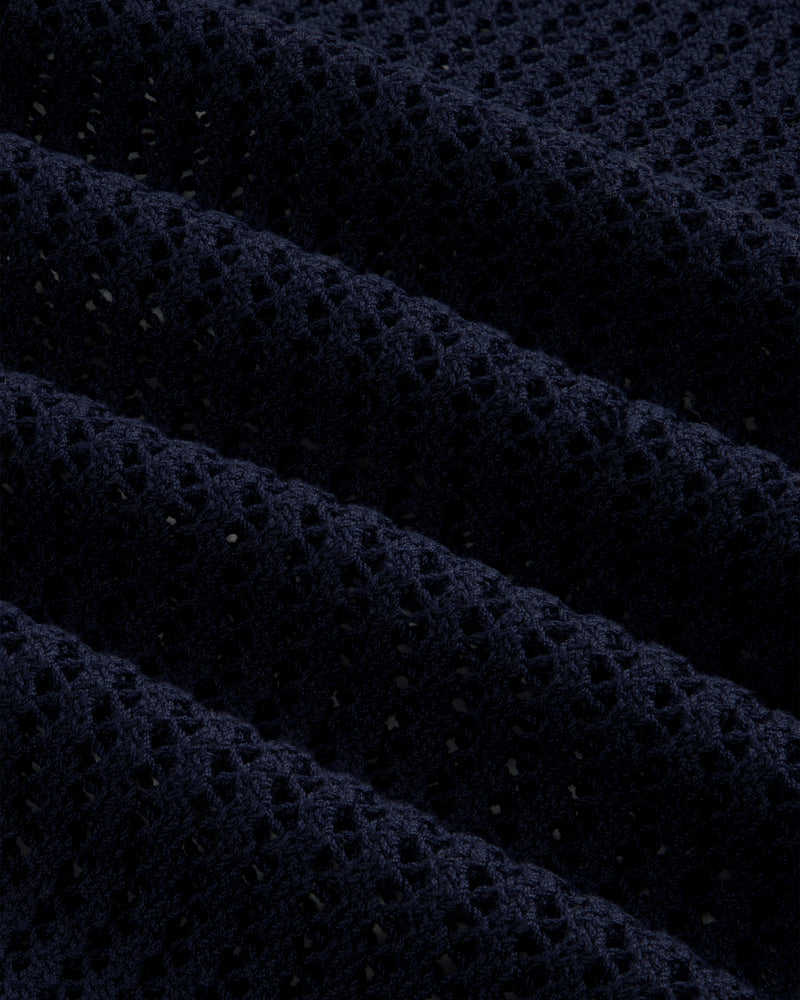 Close-up of the Cotton Eyelet Crewneck Sweater in dark blue, featuring textured waffle-knit and small perforations.
