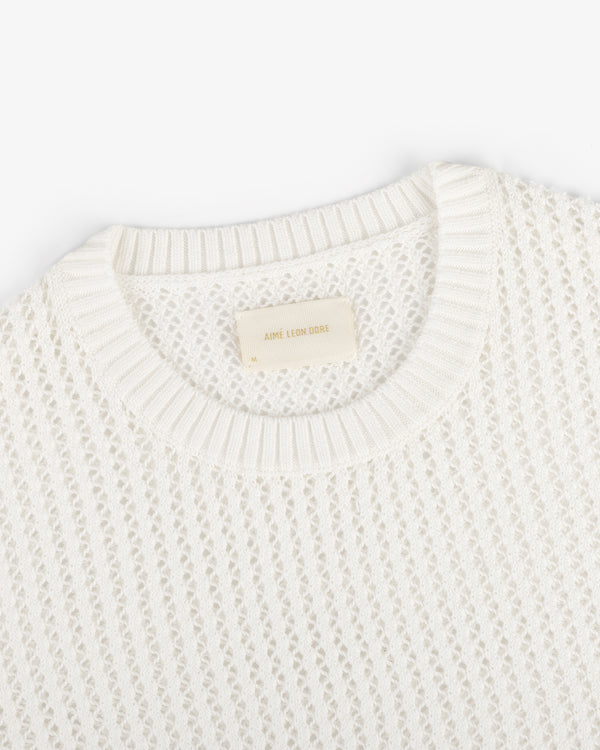 The Fassianos "Rendez-Vous" Crewneck Sweater is a white knit with a textured pattern and beige neckline label.