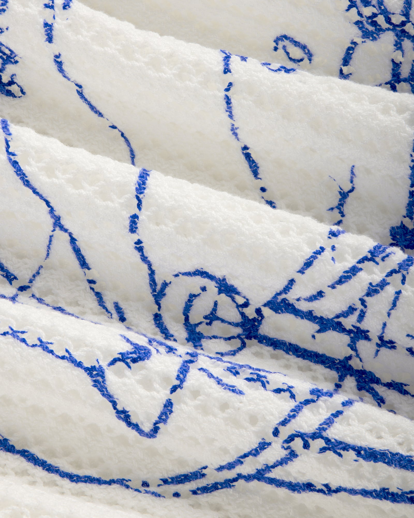 Close-up of Fassianos "Rendez-Vous" crewneck sweater’s textured white fabric with abstract blue line figures.