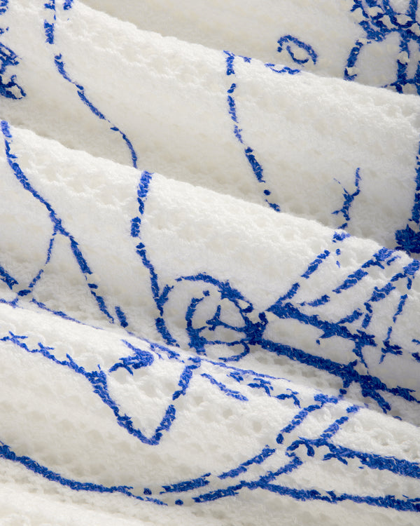 Close-up of Fassianos "Rendez-Vous" crewneck sweater’s textured white fabric with abstract blue line figures.