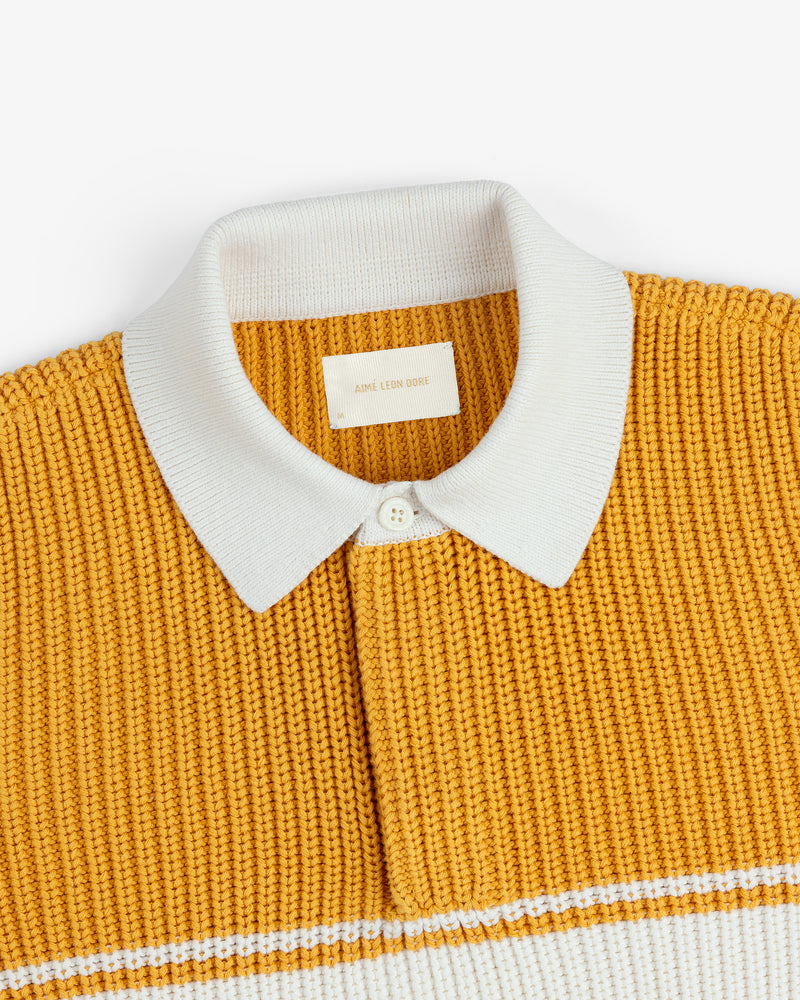 Striped Knit Rugby: Yellow shirt with white collar, button, label, and a horizontal white stripe near the bottom.