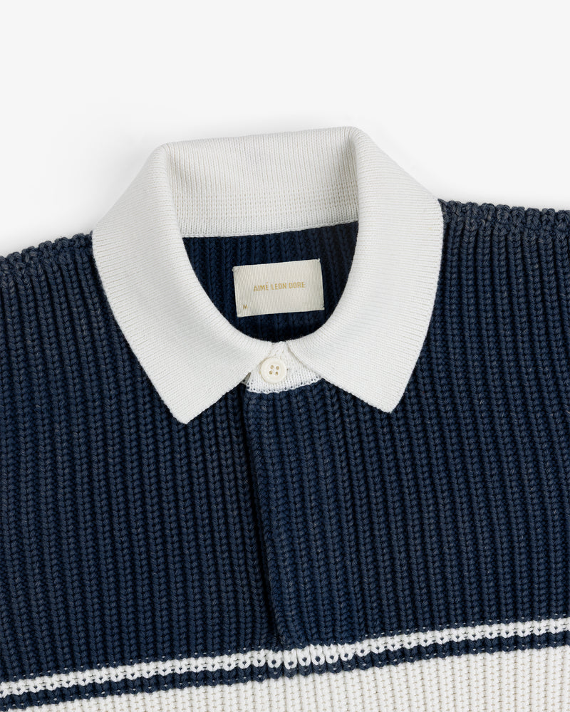 Striped Knit Rugby: Navy knit polo with white ribbed collar, button placket, and white stripes.