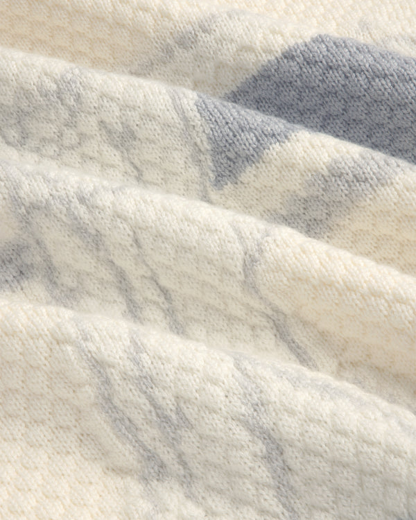 Close-up of the ALD Golf Clubhouse Sweater in soft cream knit with subtle gray patterns and gentle folds.