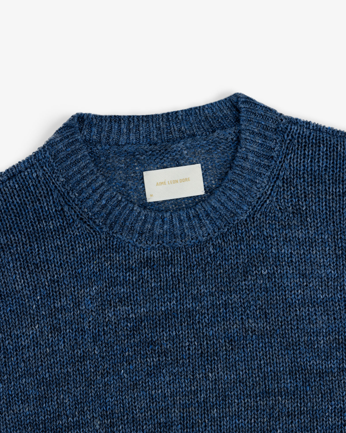 Linen Knit Crewneck Sweater with a visible fabric tag inside the collar on a plain white background.