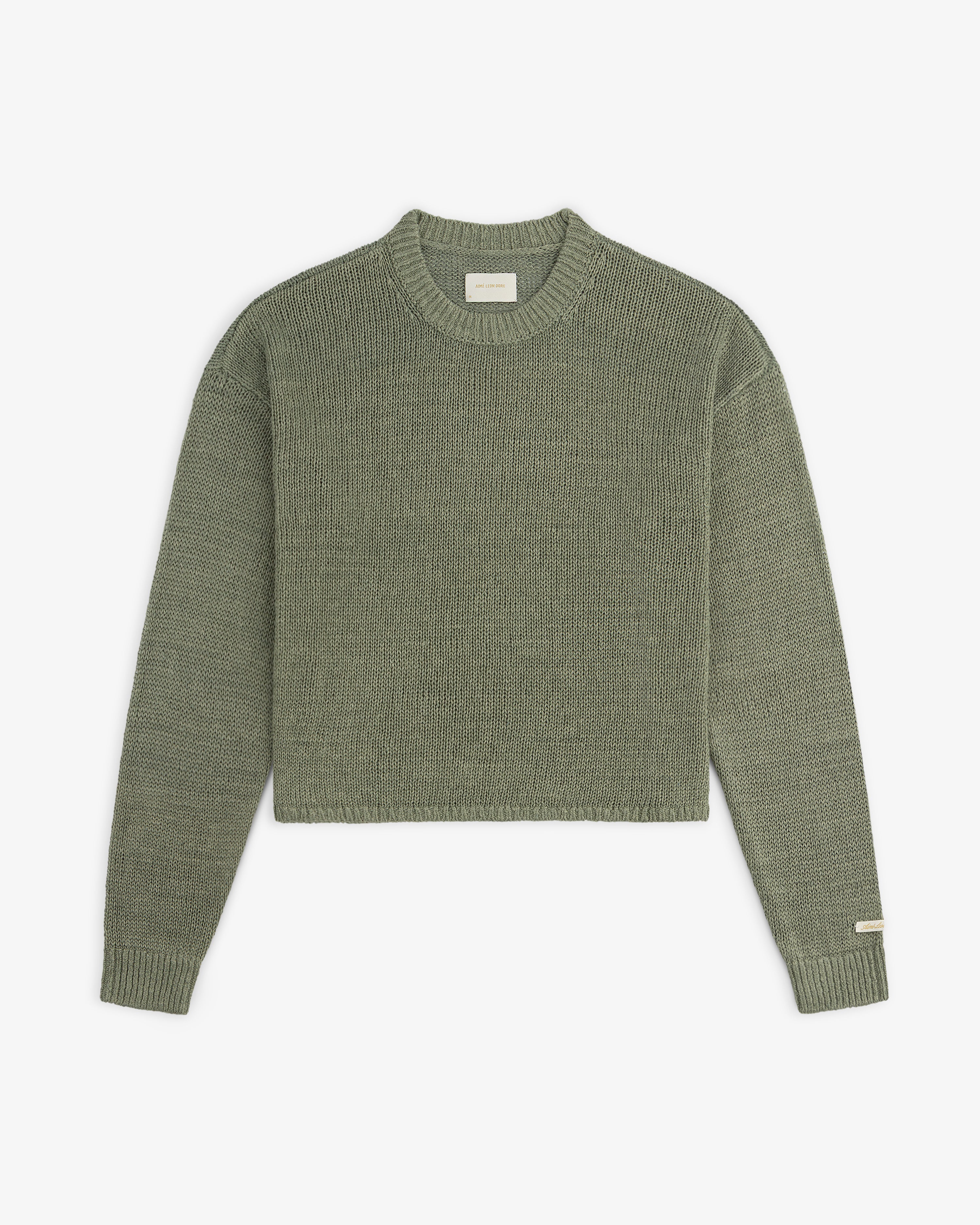 Olive green Linen Knit Crewneck Sweater with long sleeves, ribbed cuffs and hem, and a small left sleeve label.