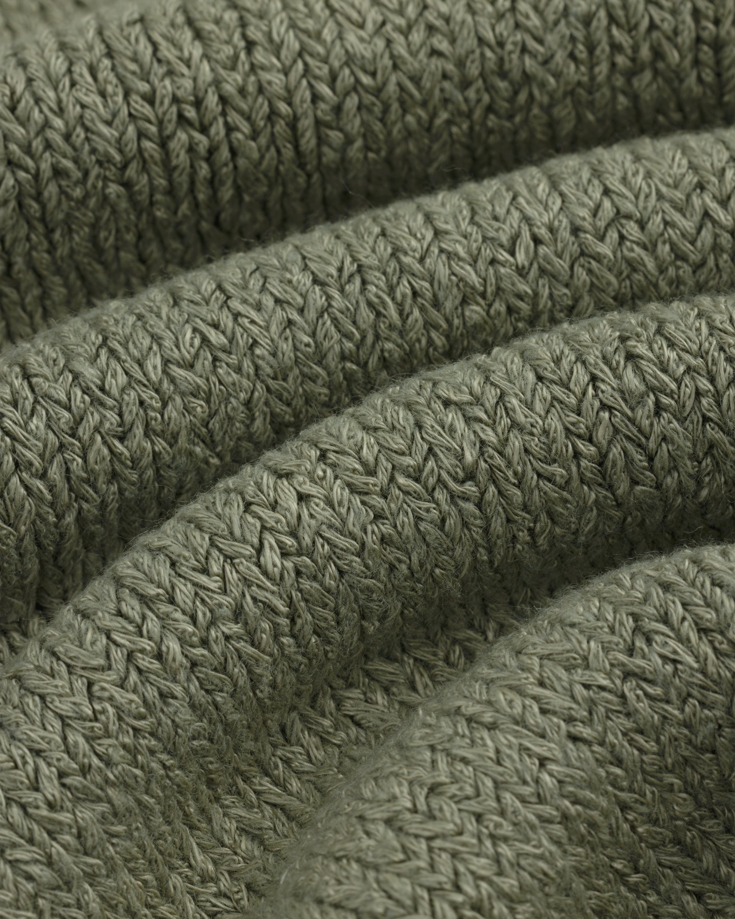 Close-up of olive green Linen Knit Drawstring Short showing textured, curved rows of stitches.