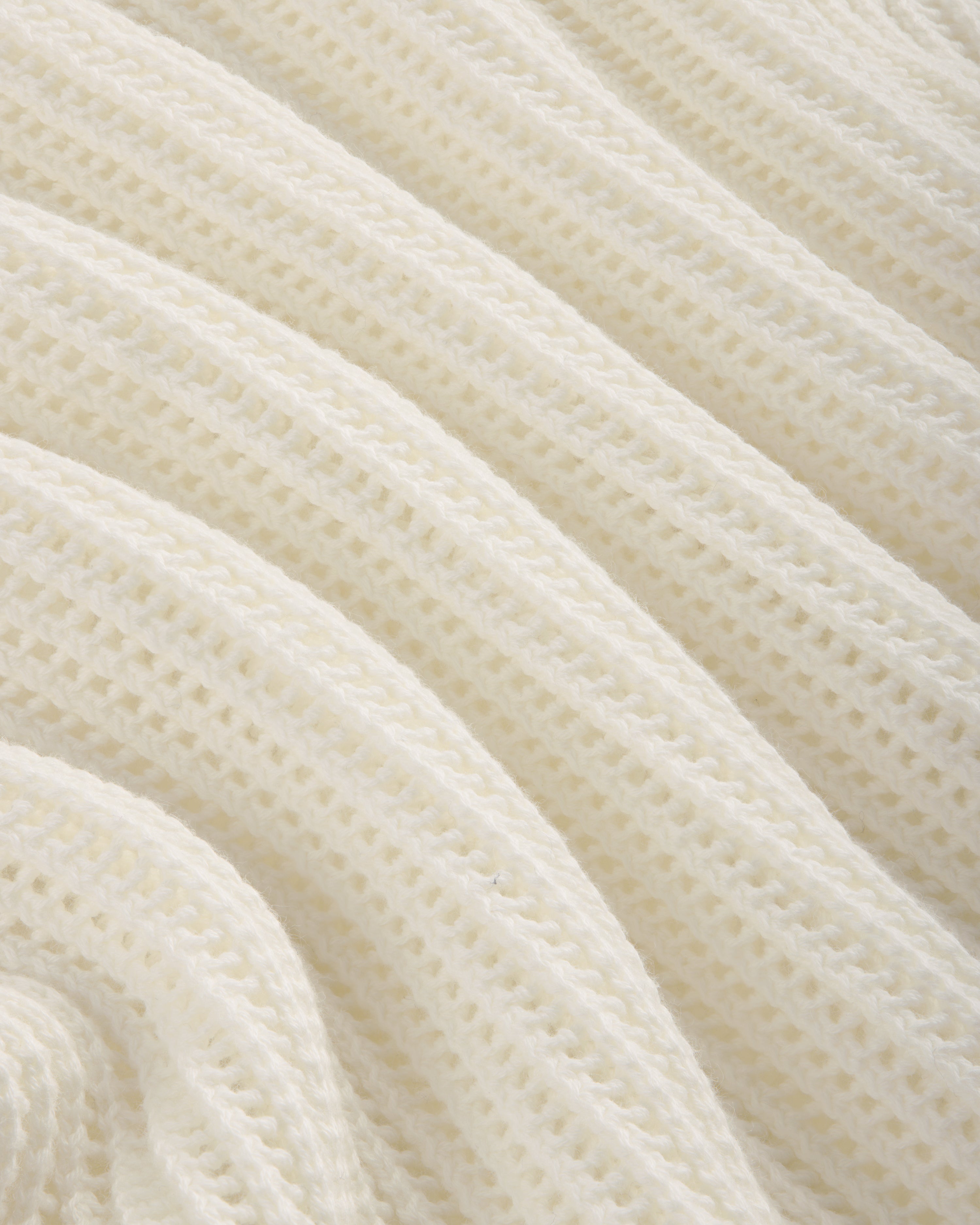 Close-up of the Mesh Knit Polo's soft, white ribbed fabric with a textured, wavy pattern.