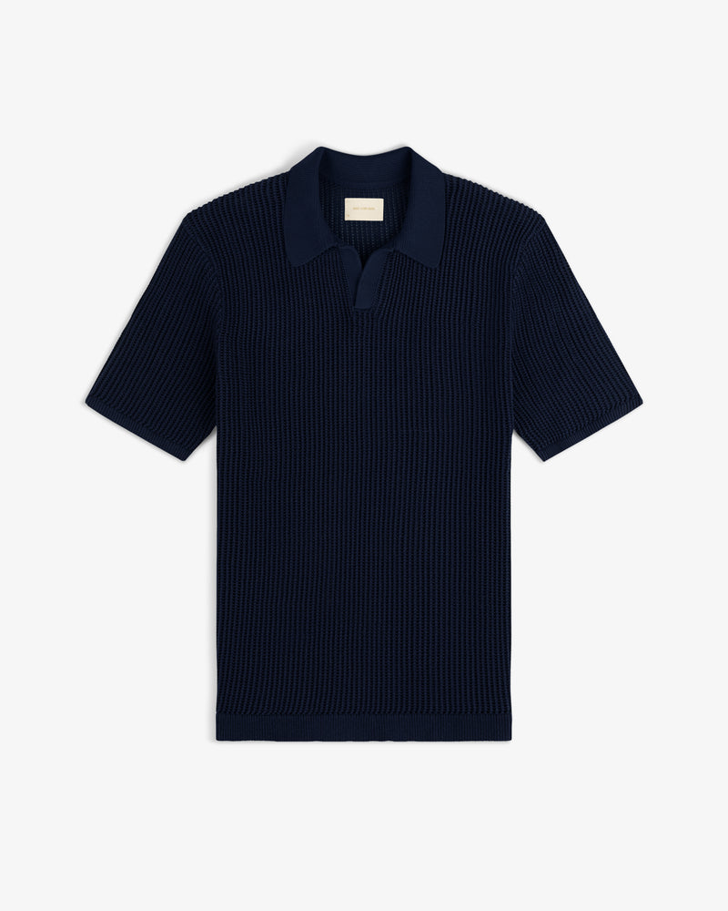 Mesh Knit Polo in navy blue with short sleeves, ribbed texture, and open collar, laid flat on white background.