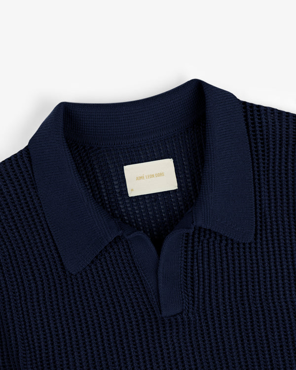 Navy blue Mesh Knit Polo featuring a textured design, spread collar, and visible Aimé Leon Dore label at the neckline.