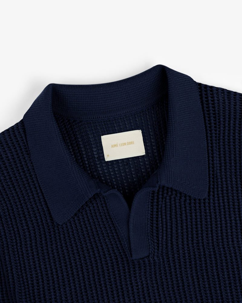 Navy blue Mesh Knit Polo featuring a textured design, spread collar, and visible Aimé Leon Dore label at the neckline.