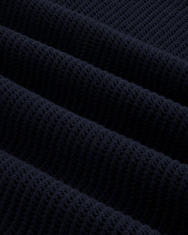 Close-up of Mesh Knit Polo’s dark navy ribbed fabric with a textured, repeating diagonal pattern.