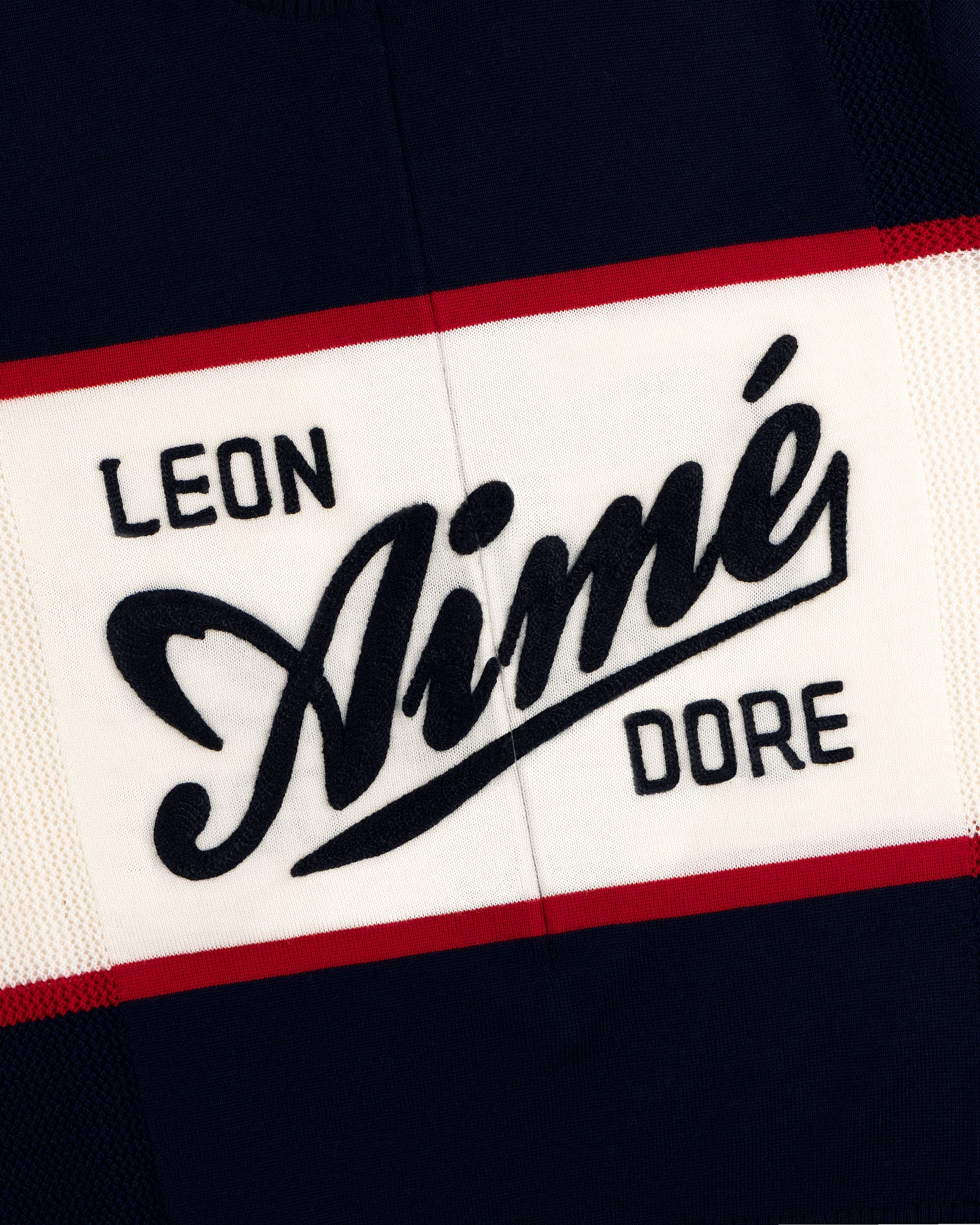 A navy, white, and red Merino Wool Cycling Jersey with Leon Aimé Dore written across the front.