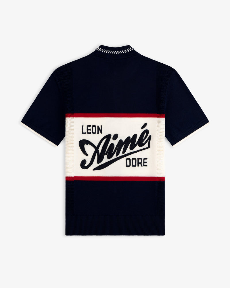 Navy Merino Wool Cycling Jersey with bold LEON Aimé DORE text on a cream panel, bordered by red stripes.