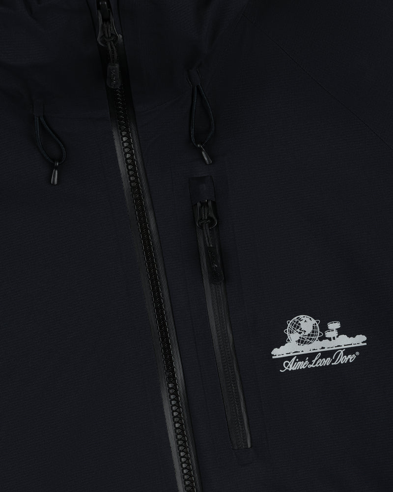 Close-up of black Lightweight GORE-TEX Shell Jacket with zipper and white Aimé Leon Dore globe and tree logo.