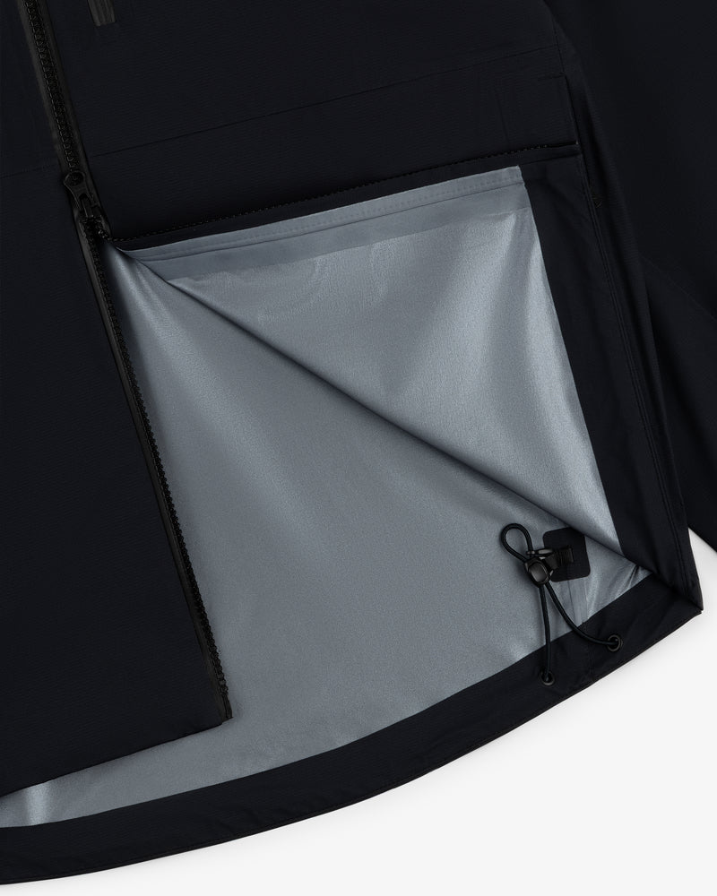 Close-up of a Lightweight GORE-TEX Shell Jacket, showing its gray lining and adjustable drawstring on the open side.