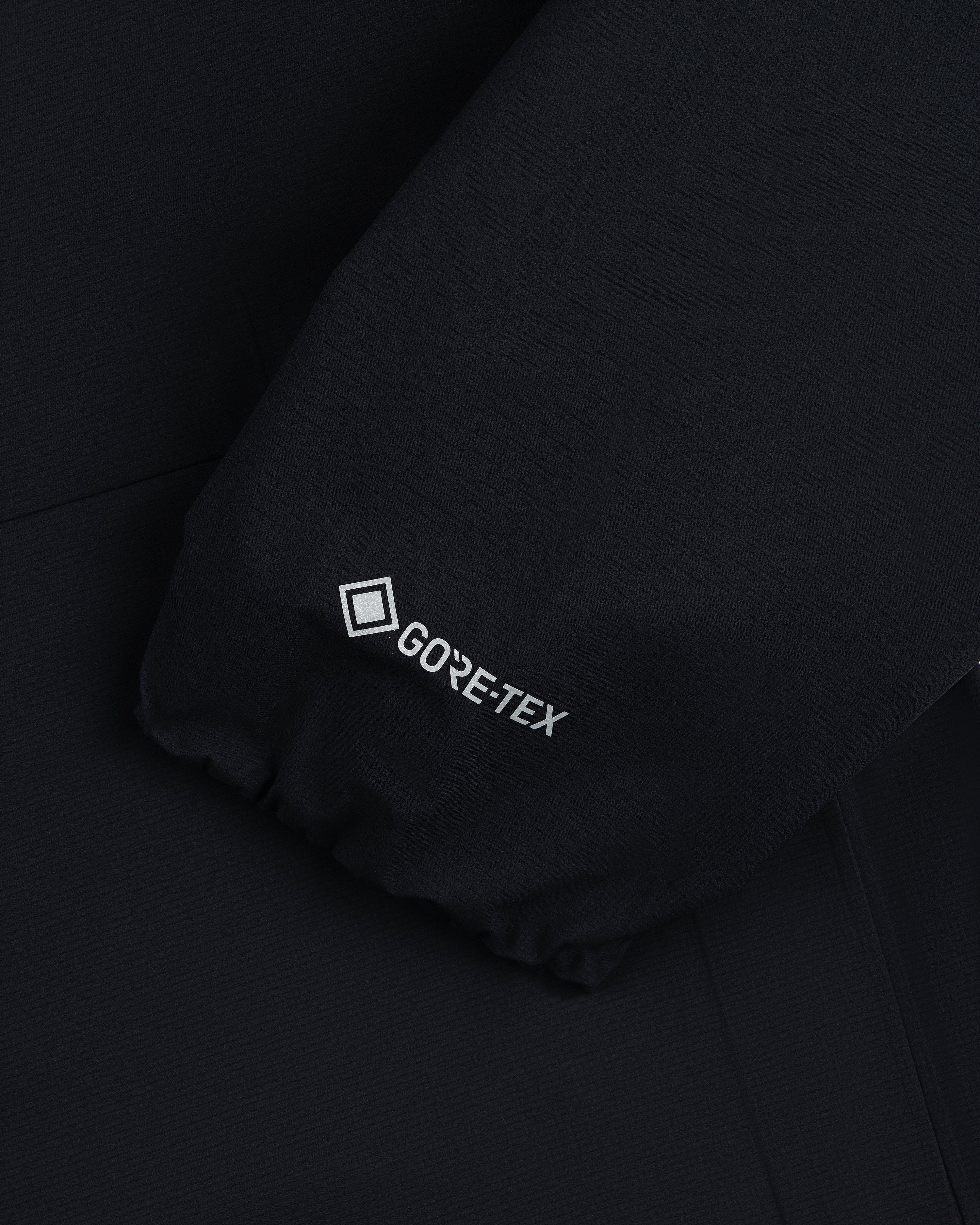 Close-up of Lightweight GORE-TEX Shell Jacket's black sleeve with white GORE-TEX logo near the cuff.