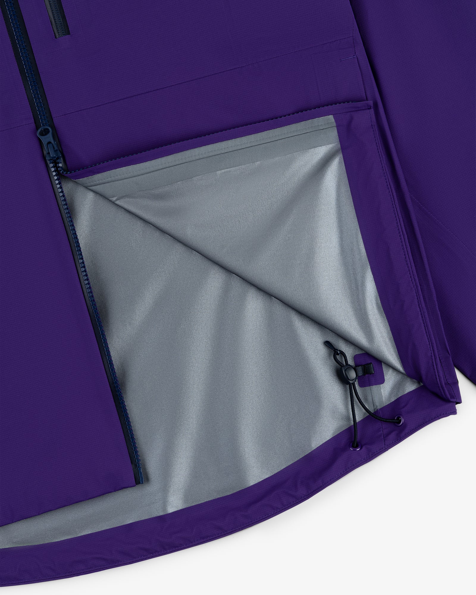 Close-up of the Lightweight GORE-TEX Shell Jacket in purple with a gray lining and partially unzipped side pocket.