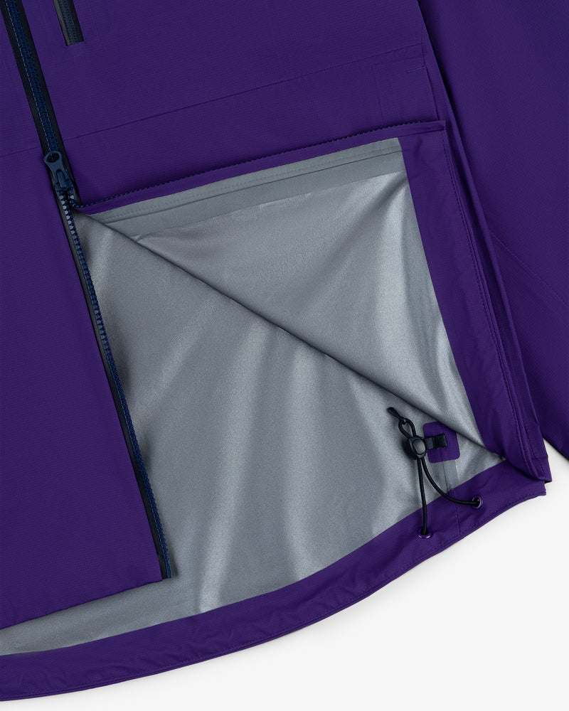 Close-up of the Lightweight GORE-TEX Shell Jacket in purple with a gray lining and partially unzipped side pocket.