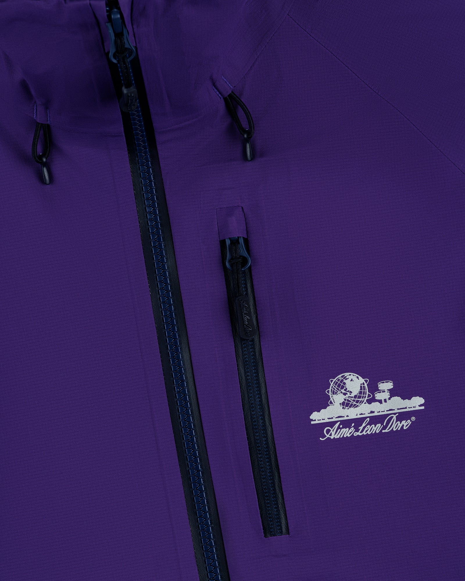 Close-up of Lightweight GORE-TEX Shell Jacket in purple with chest zipper pocket and Aimé Leon Dore globe logo.