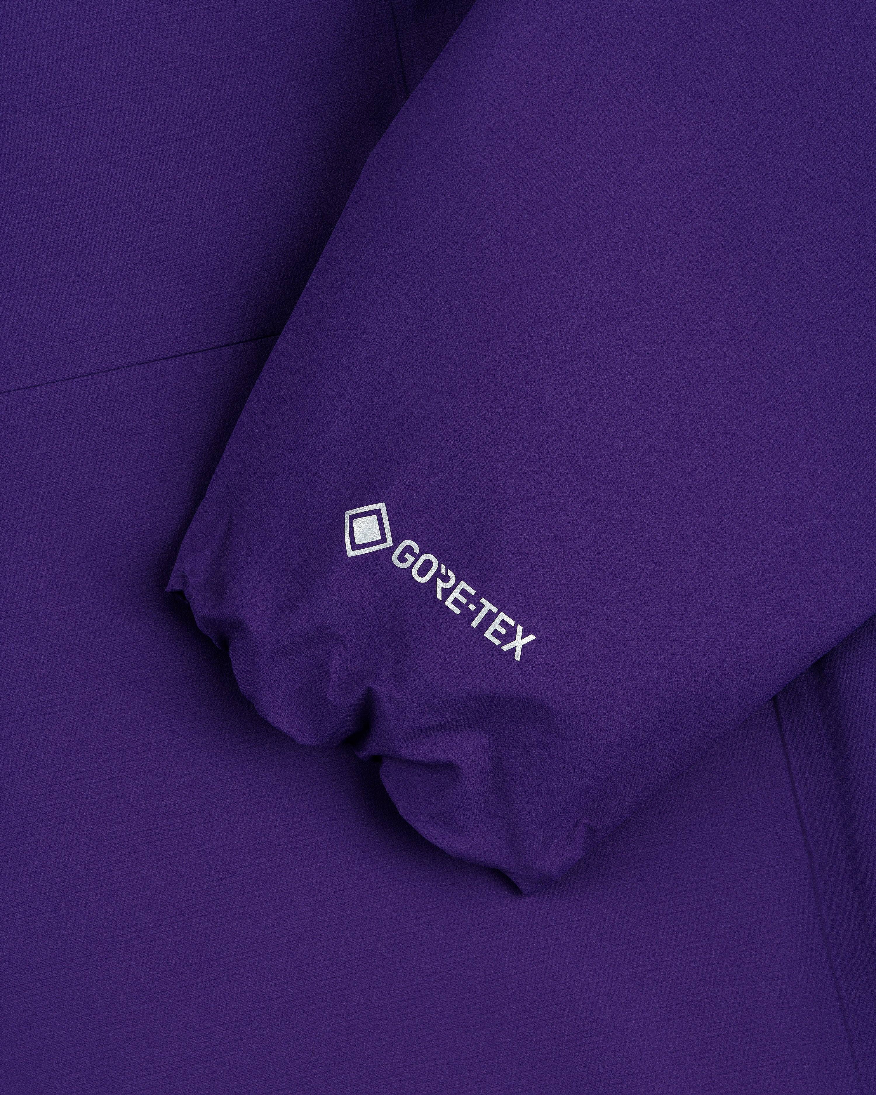 Close-up of the Lightweight GORE-TEX Shell Jacket's purple sleeve with white GORE-TEX logo.