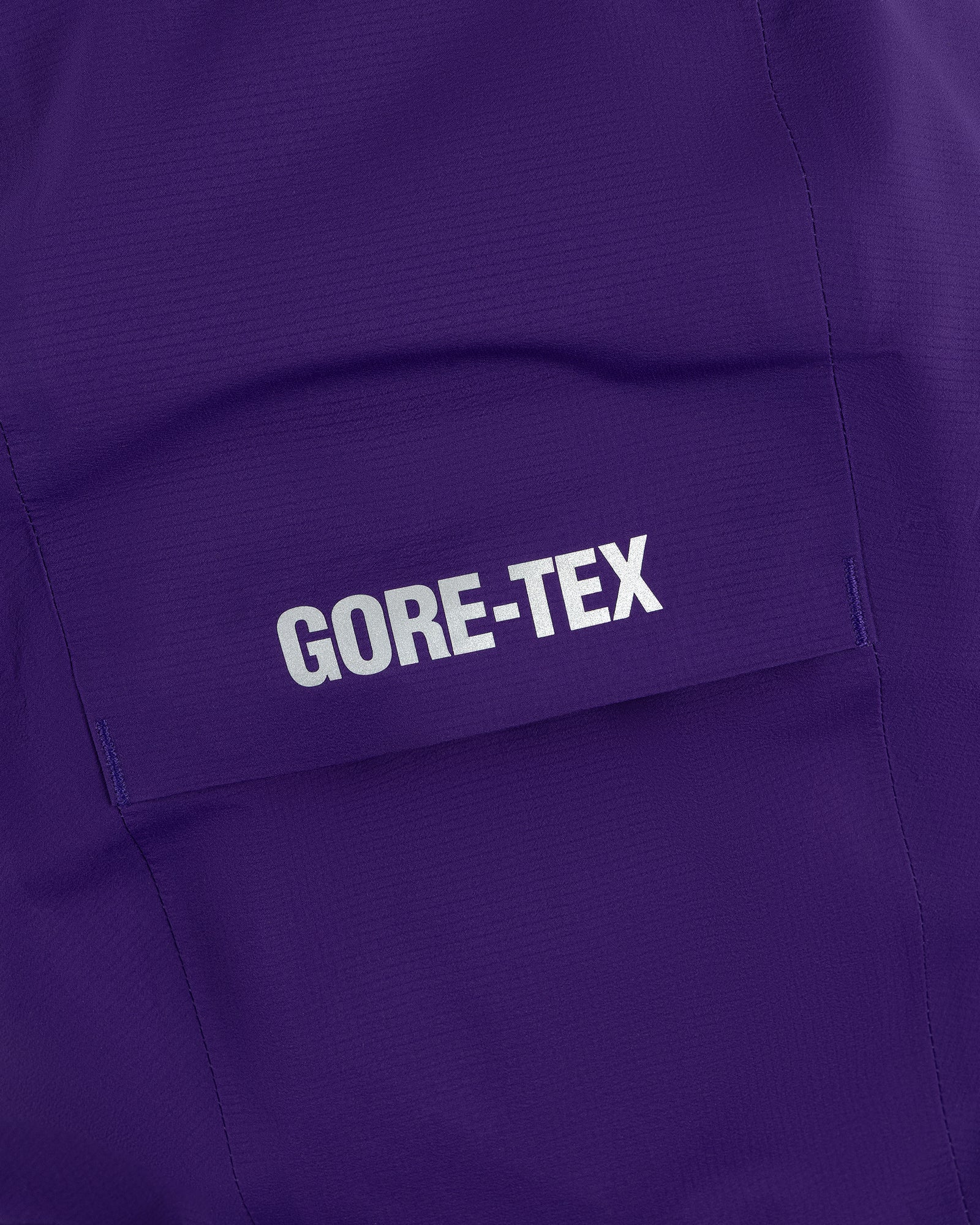 Close-up of a purple pocket from the Lightweight GORE-TEX Shell Jacket with a white GORE-TEX logo.