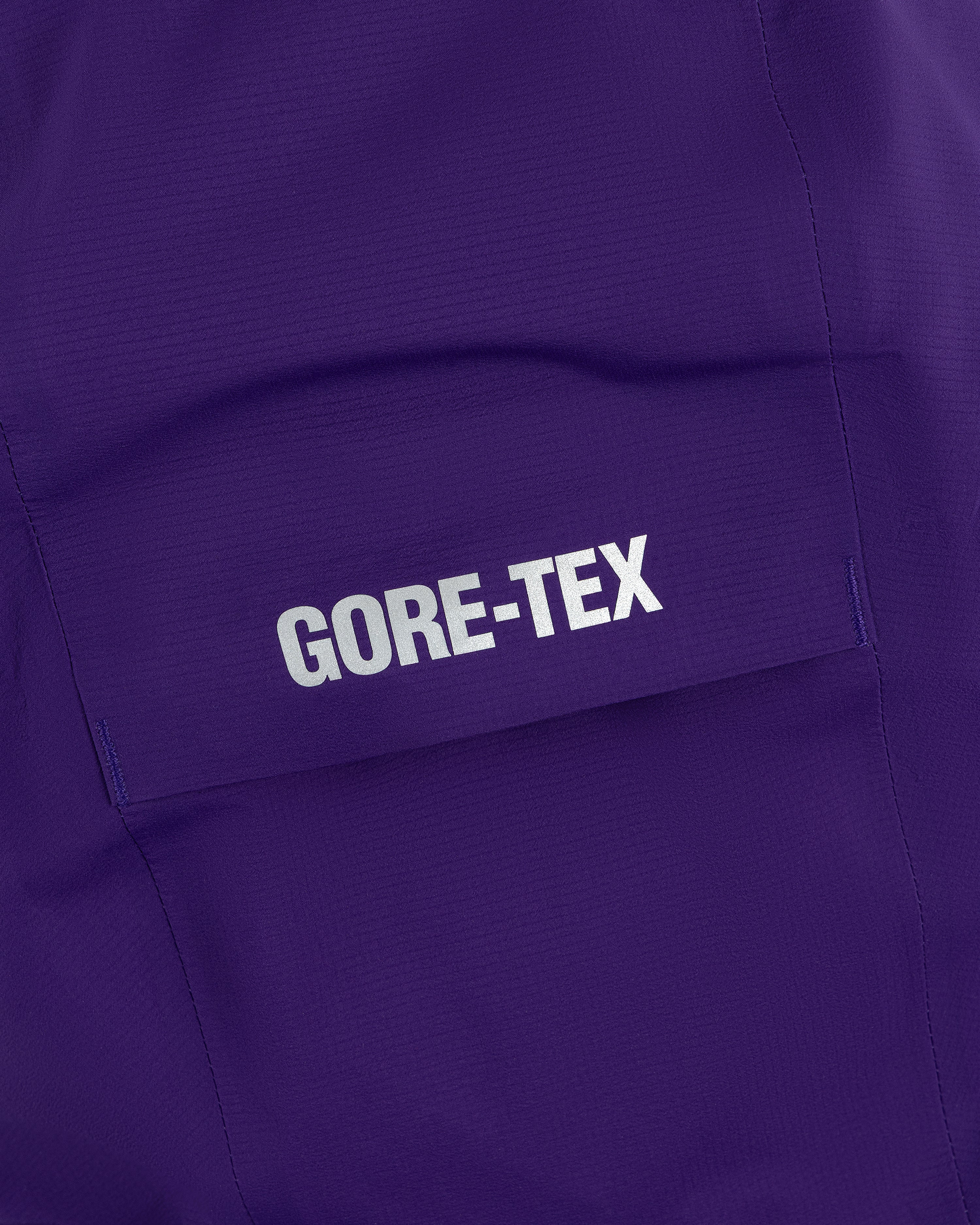 Close-up of a purple pocket from the Lightweight GORE-TEX Shell Jacket with a white GORE-TEX logo.