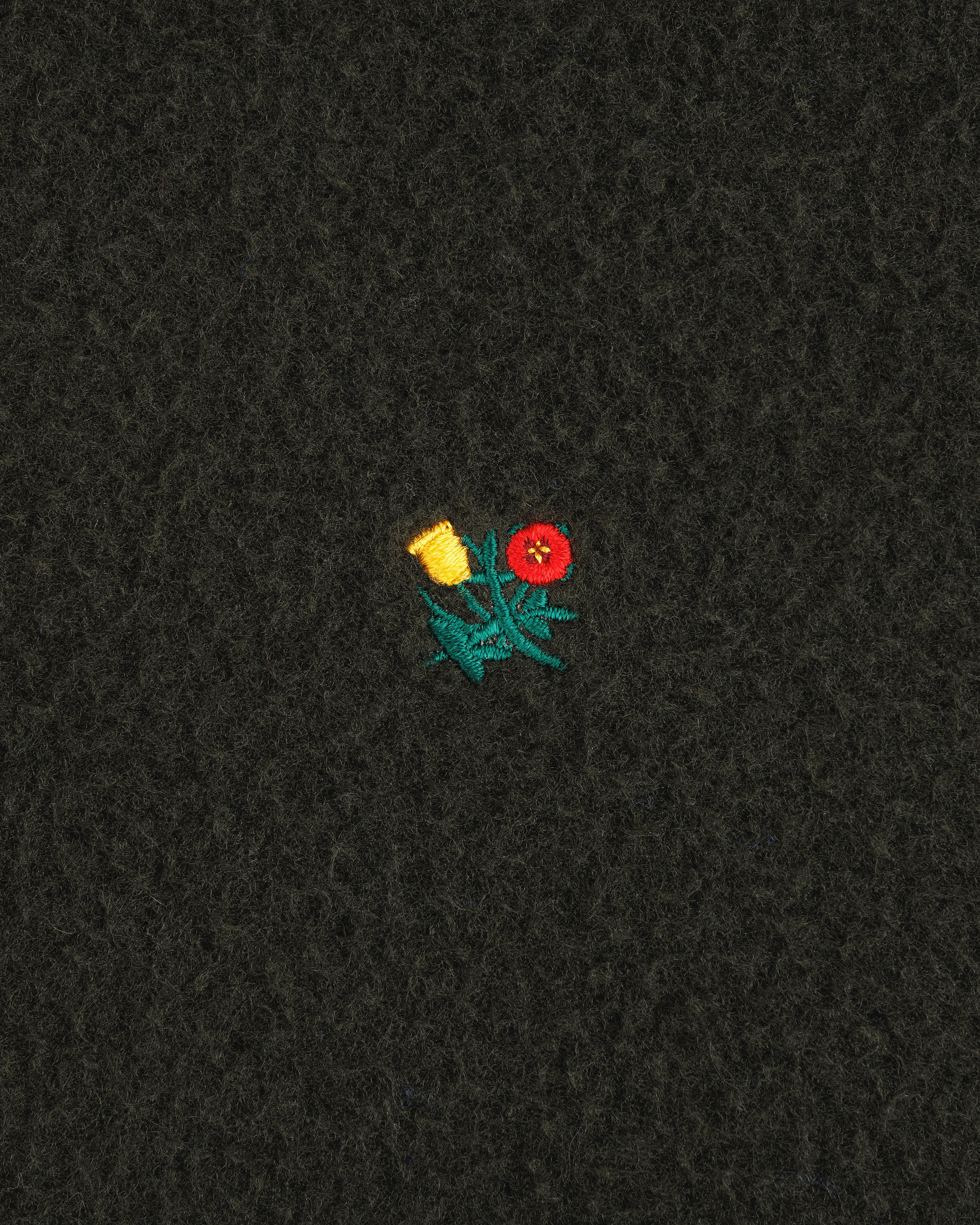 A small embroidered yellow and red flower with green leaves features on the Casentino Crest Half-Zip Pullover.