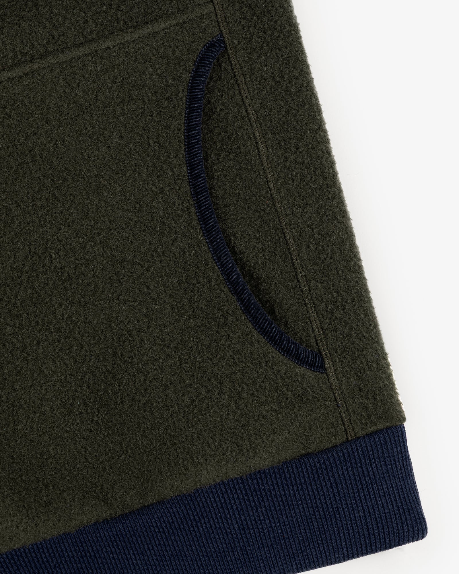 Close-up of the Casentino Crest Half-Zip Pullover in olive green with navy ribbed pocket trim and hem on white background.